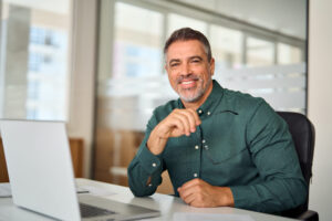 happy-mid-aged-professional-business-man-sits-at-w-2023-11-27-05-16-33-utc-2048x1366