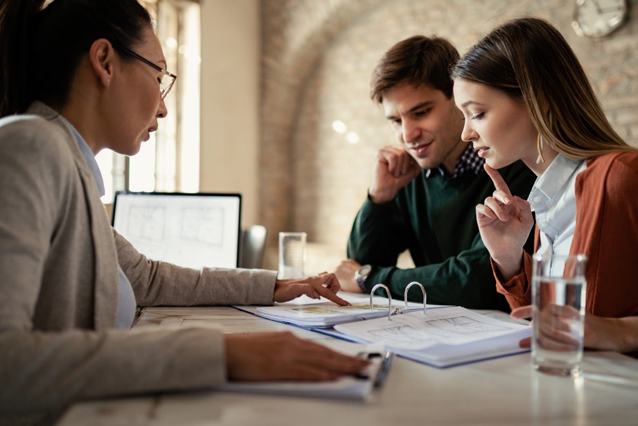 casal jovem analisando planos de consórcio com corretora