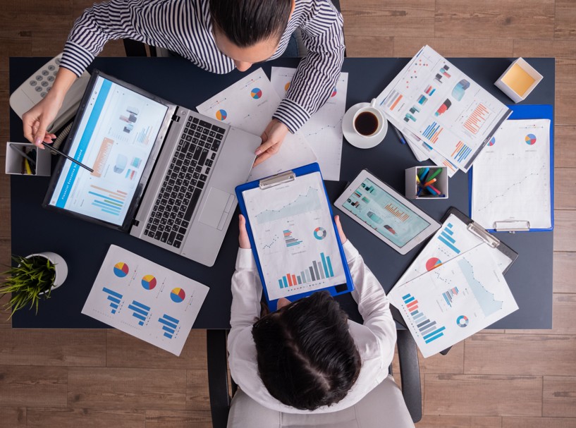 automação Dois corretores de seguros: um trabalhando com muitos papéis e o outro só com um computador.